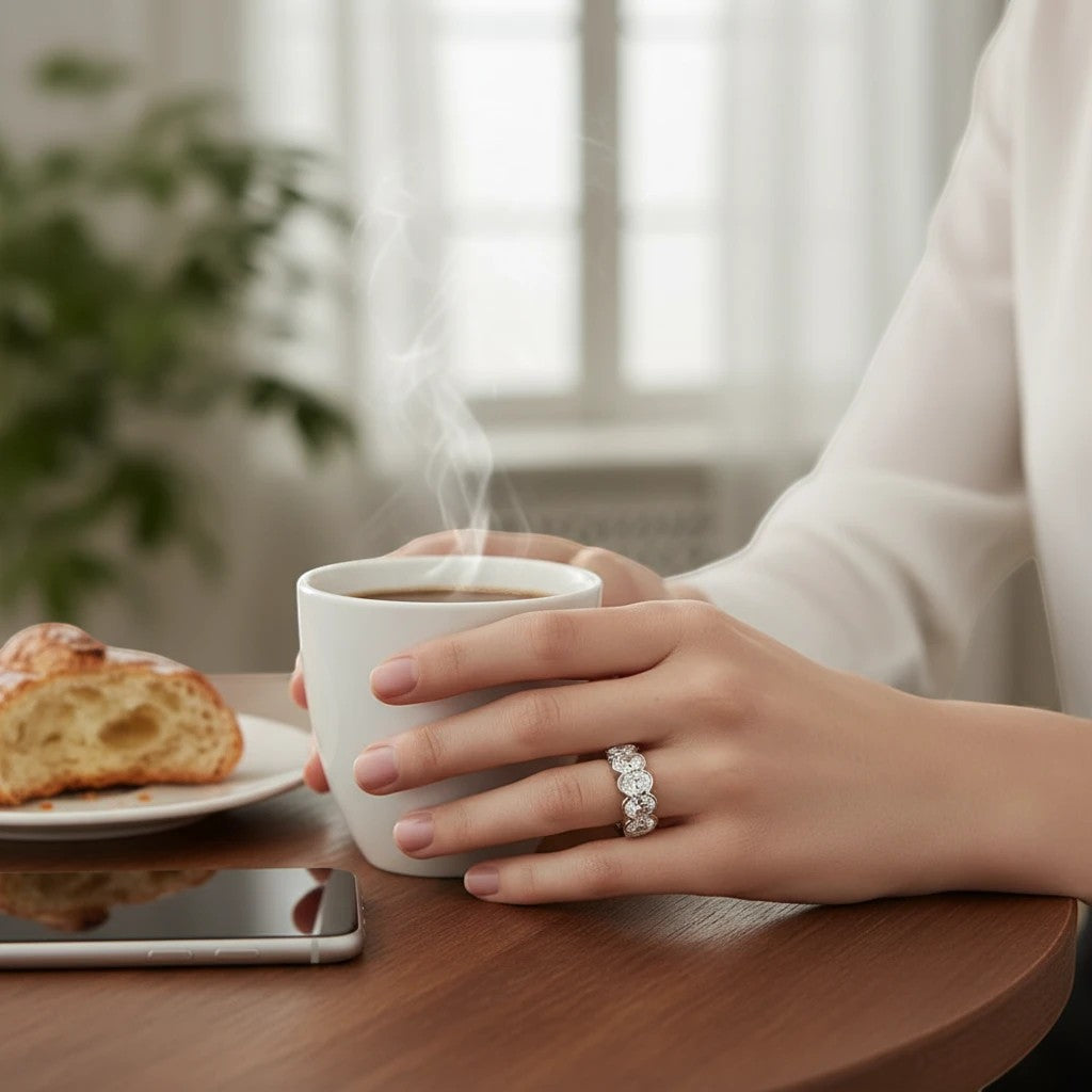 Bee-Bees 0.5ct oval moissanite eternity band in 18k white gold plated sterling silver worn on a woman's hand