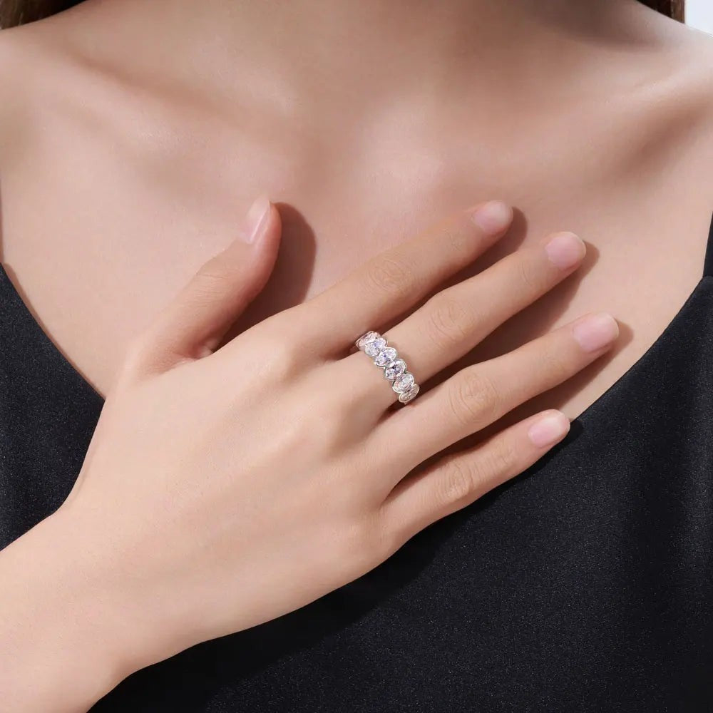 Bee-Bees 0.5ct oval-cut moissanite eternity band in 18k white gold plated sterling silver worn on a hand