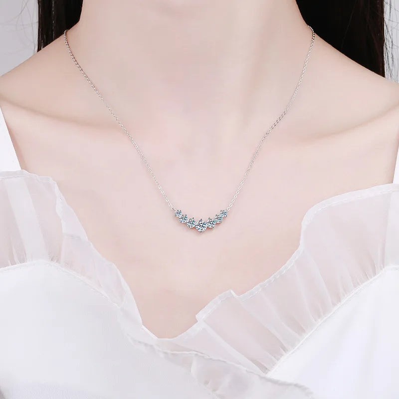 Bee-Bee's sterling silver necklace with a curved row of seven sparkling oval moissanite stones.