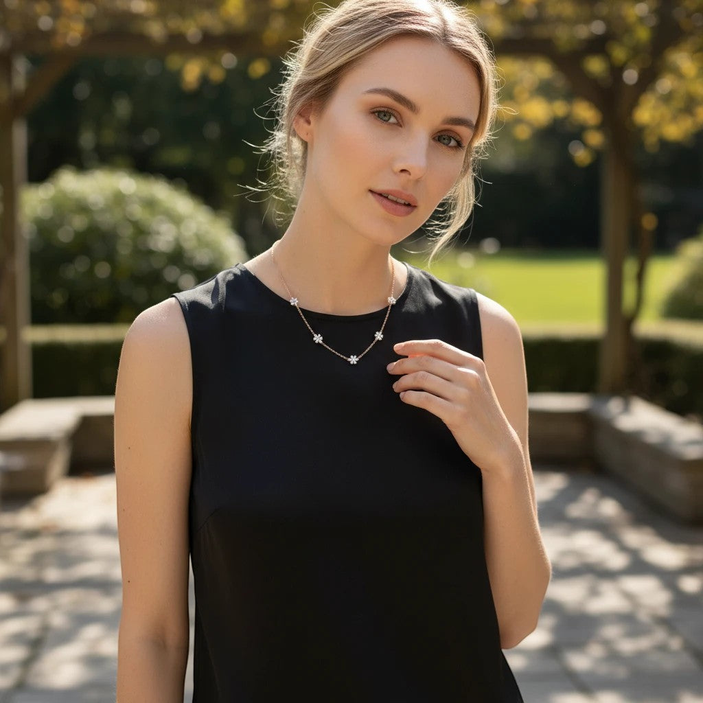 Bee-Bee's sterling silver necklace with five small flower charms, each with a pear-cut moissanite stone.