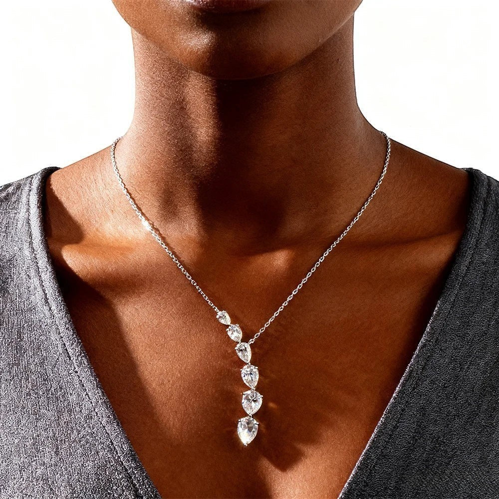 Bee-Bee's 7.6ct pear cut moissanite necklace with 5 graduated stones on a silver chain, D color, VVS1 clarity, GRA certified.