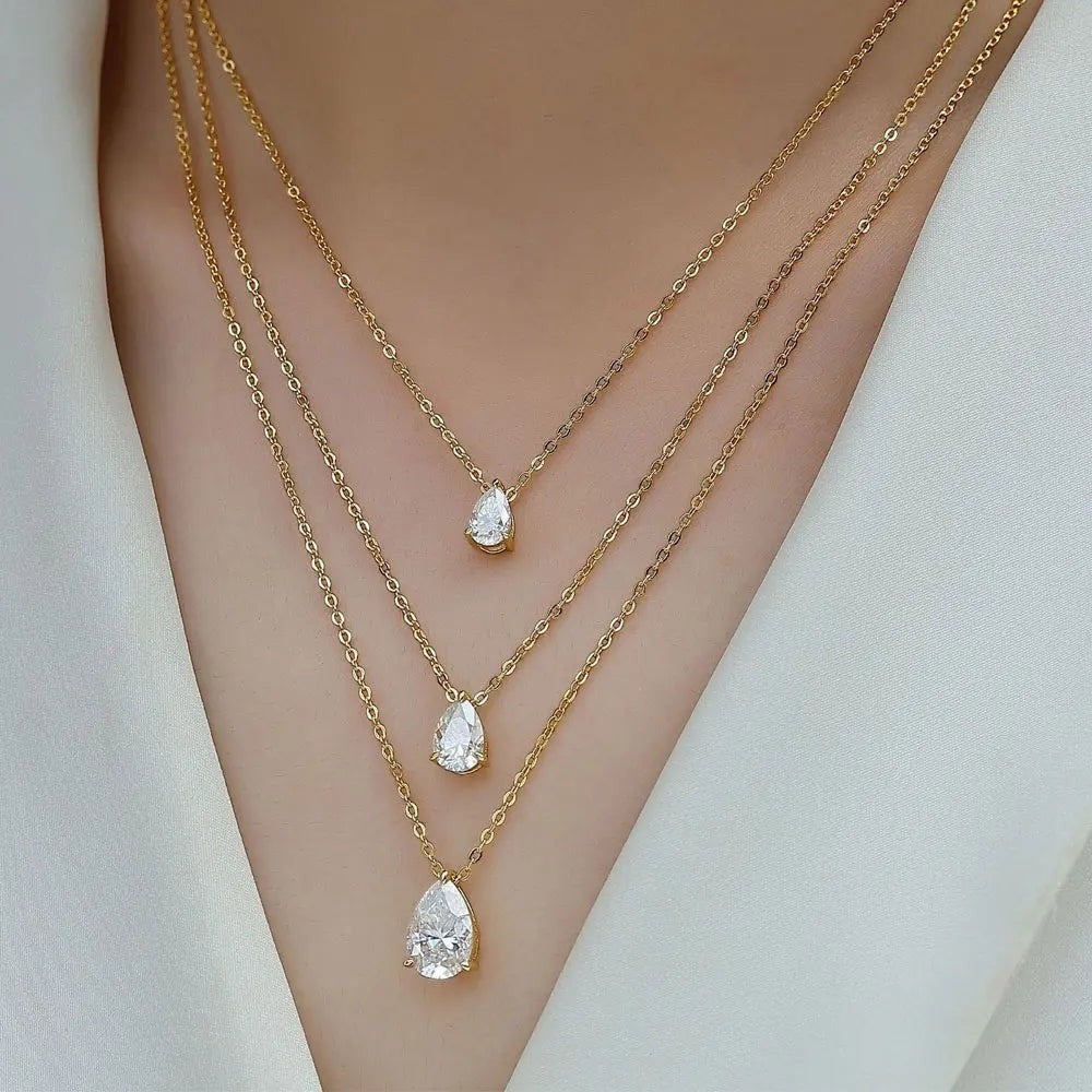 Bee-Bee's layered gold necklaces with pear-cut moissanite pendants in 1ct, 3ct, and 5ct sizes.