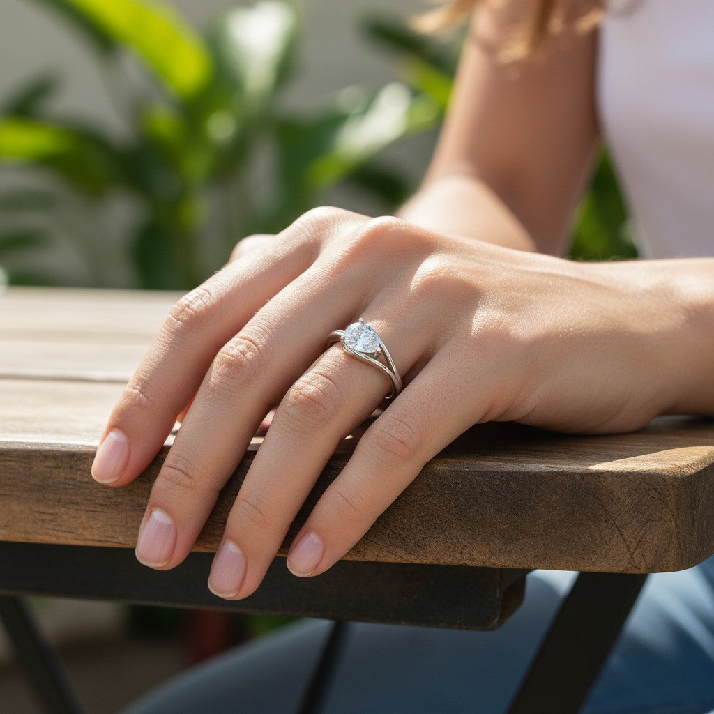Bee-Bees 1ct pear cut moissanite engagement ring in s925 sterling silver worn on a woman's finger