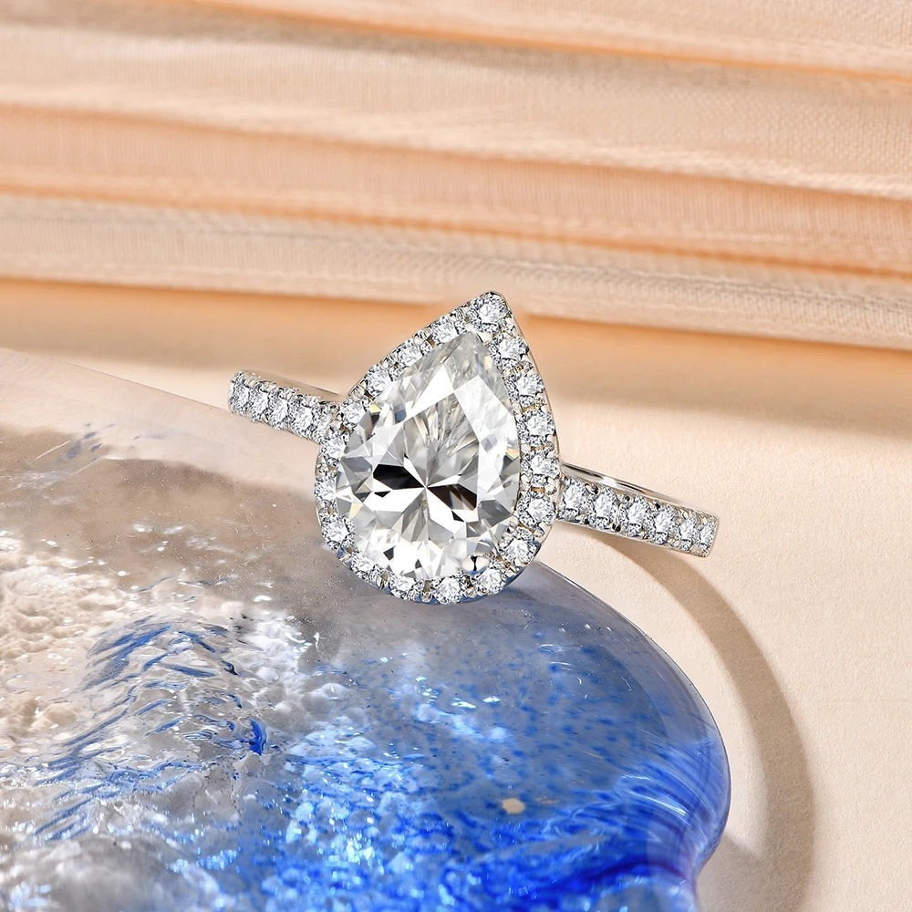 Bee-Bees 2.0CT pear cut moissanite engagement ring with a halo setting on a 925 sterling silver band.
