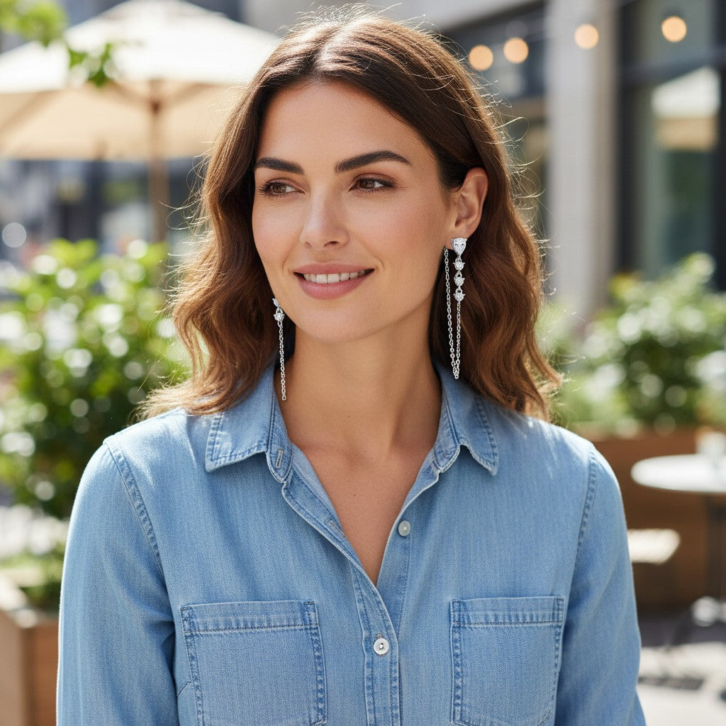 Bee-Bees pear cut moissanite tassel earrings in S925 sterling silver worn by a woman in a casual denim shirt.