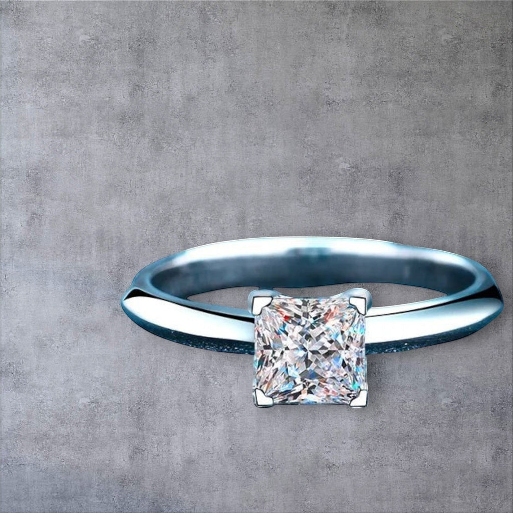 Bee-Bees Princess cut moissanite engagement ring in sterling silver with 18K white gold plating.
