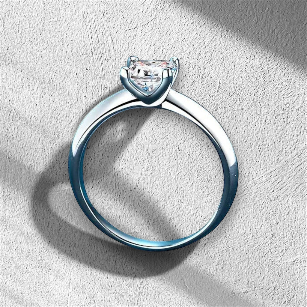 Bee-Bees Princess cut moissanite ring in sterling silver with 18K white gold plating. Features a D VVS1 stone.