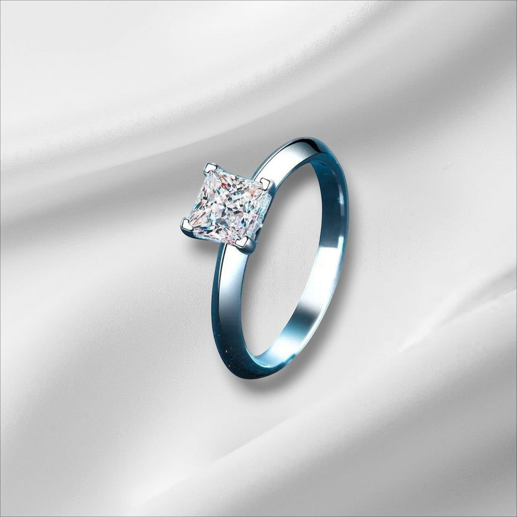 Bee-Bees Princess cut moissanite ring in sterling silver with 18k white gold plating. Features a D VVS1 stone.