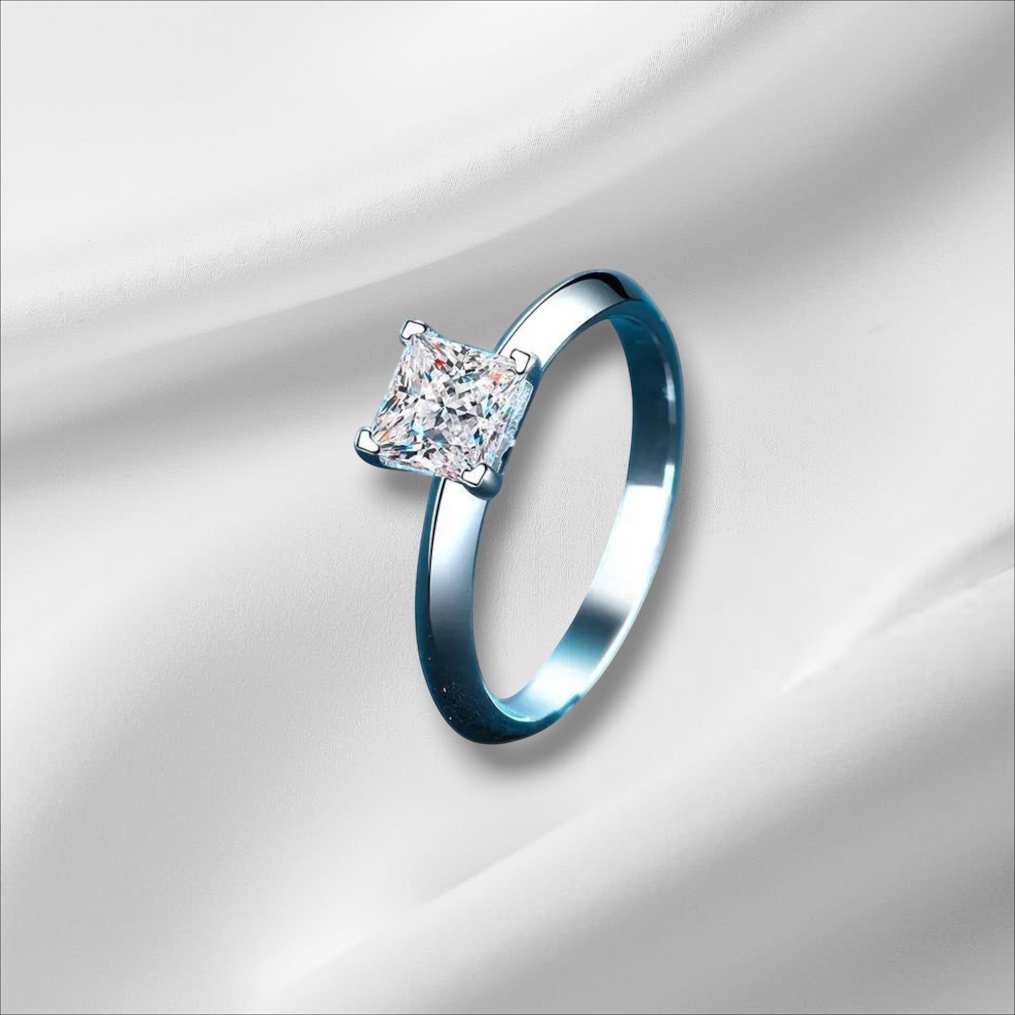 Bee-Bees Princess cut moissanite ring in sterling silver with 18k white gold plating. Features a D VVS1 stone.