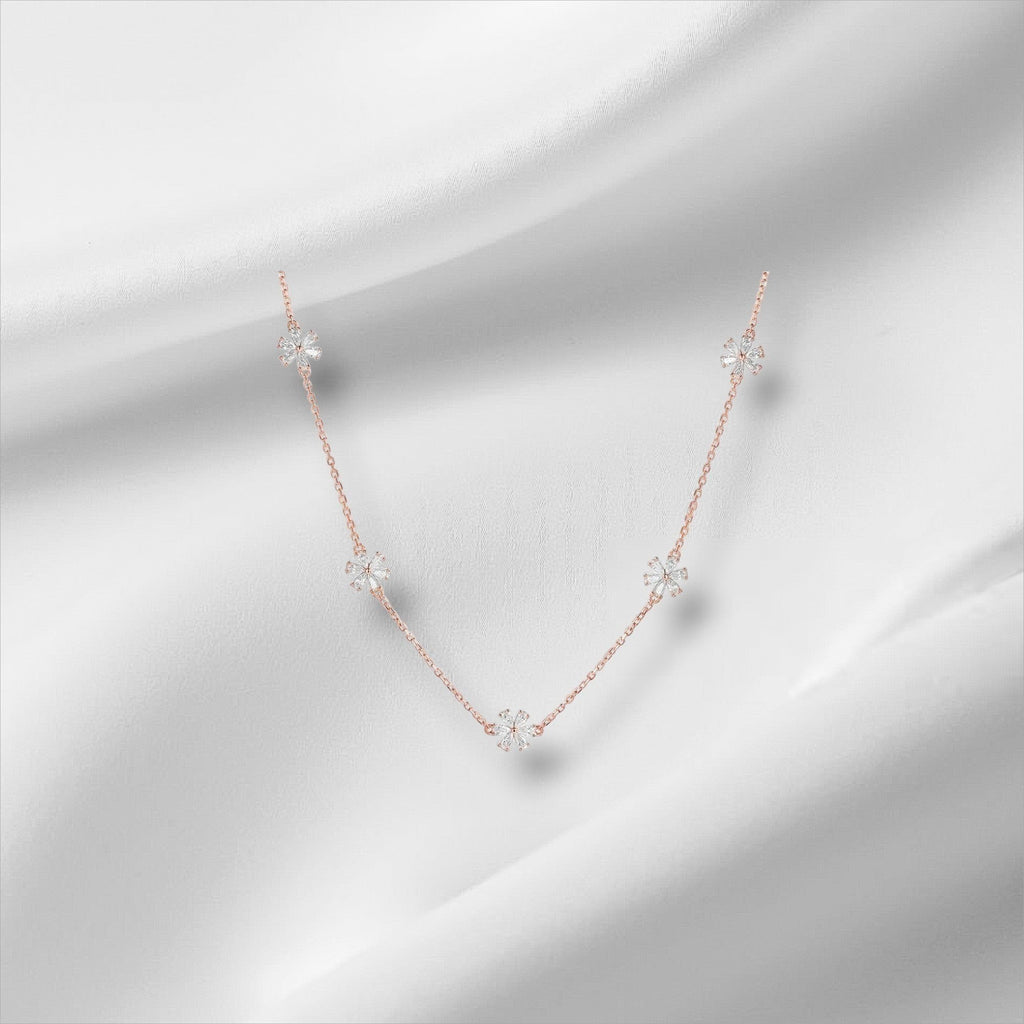 Bee-Bee's rose gold sterling silver necklace with five small flower charms, each set with sparkling moissanite stones.