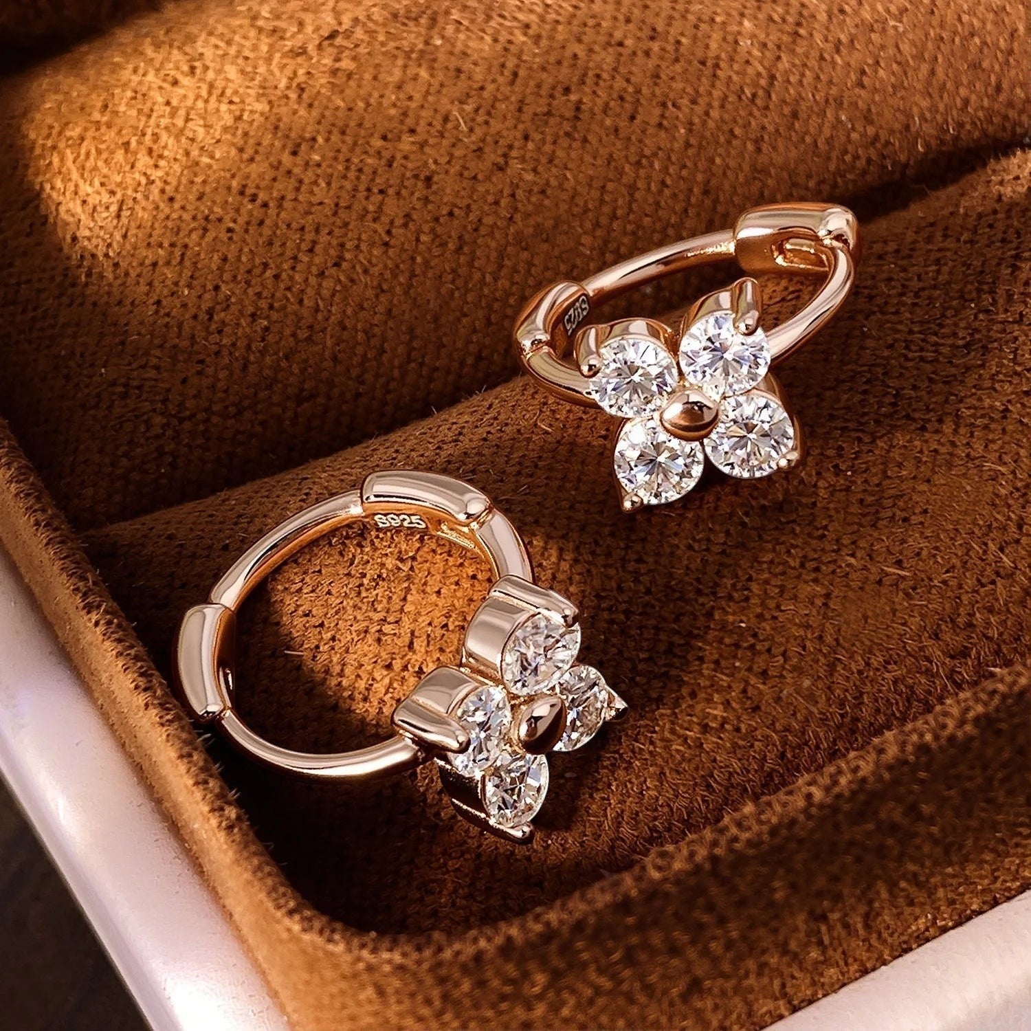 Bee-Bees rose gold plated sterling silver hoop earrings with four clear cubic zirconia stones arranged in a flower shape.