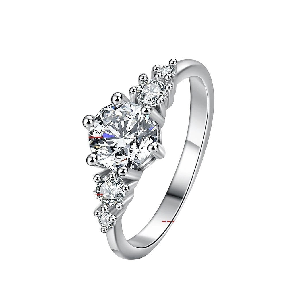 Bee-Bees 1ct round moissanite engagement ring in sterling silver with 18k white gold plating. Features a solitaire stone with accent stones.