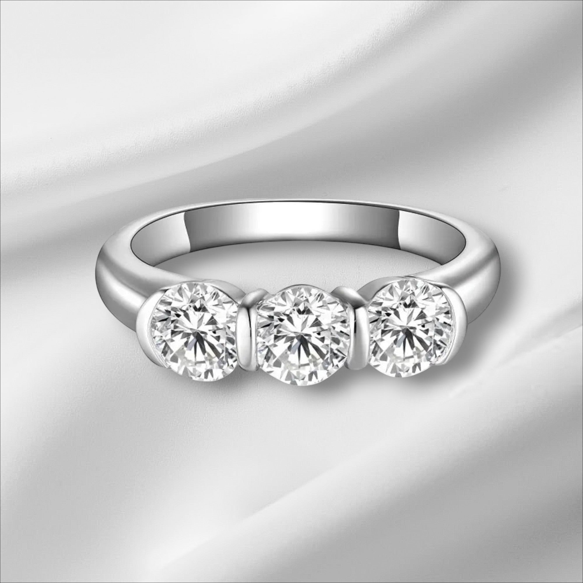 Bee-Bees 5mm round moissanite engagement ring in 925 sterling silver with 18k white gold plating. Features three brilliant-cut stones.