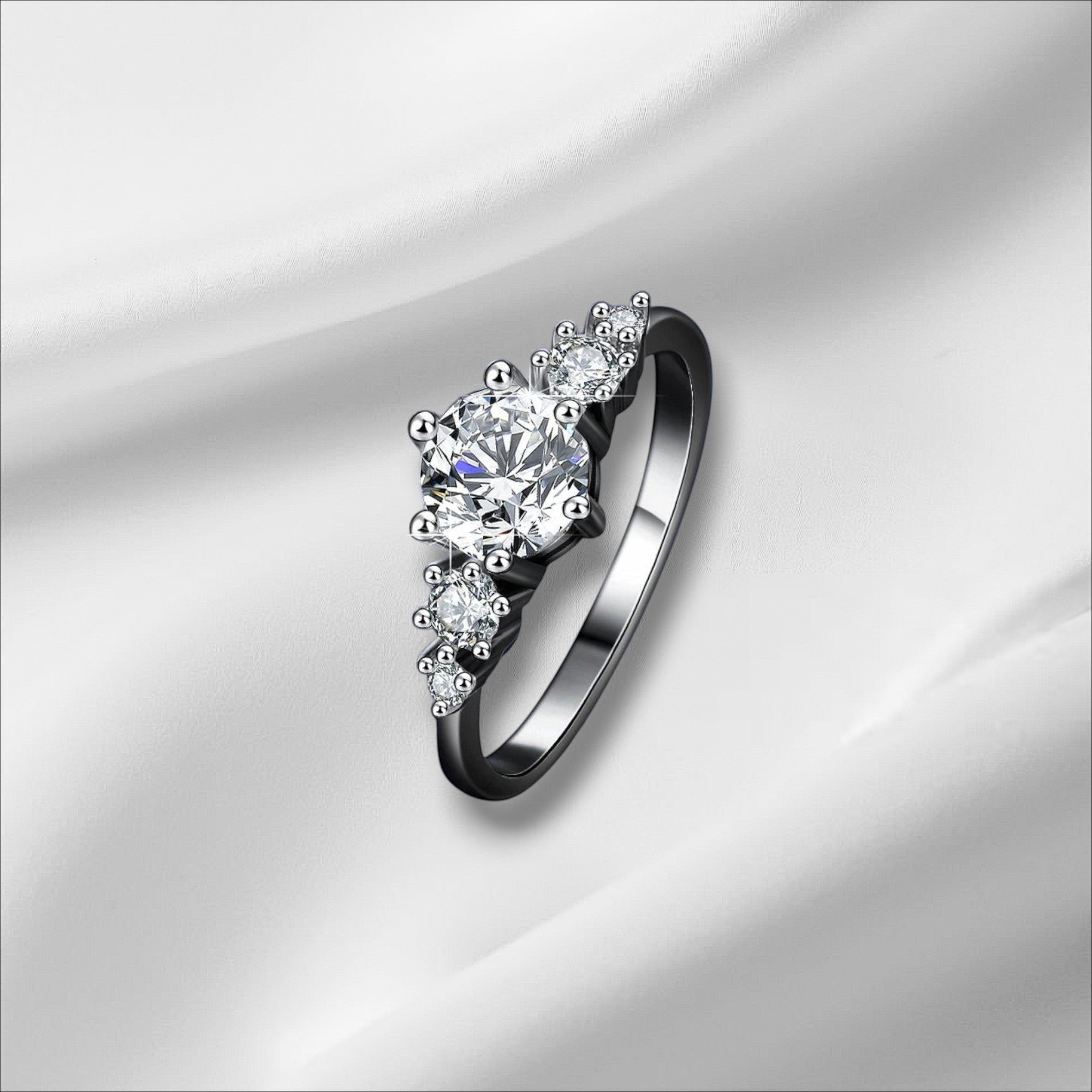 Bee-Bees 1ct round moissanite engagement ring in s925 sterling silver with 18k white gold plating. Features a central solitaire stone with smaller accent stones.