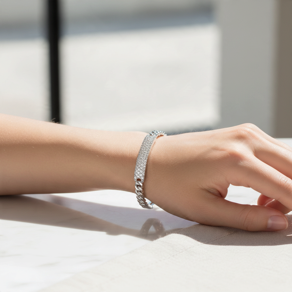 Bee-Bees sterling silver Cuban link bangle featuring sparkling D color VVS1 moissanite stones on a woman's wrist.