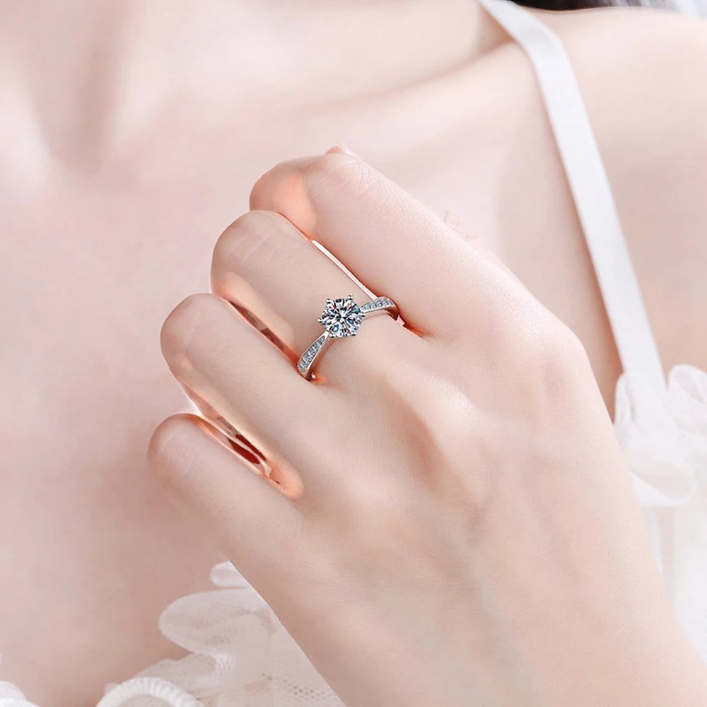 Bee-Bee's sterling silver solitaire engagement ring with round D VVS1 moissanite and small accent stones on band.