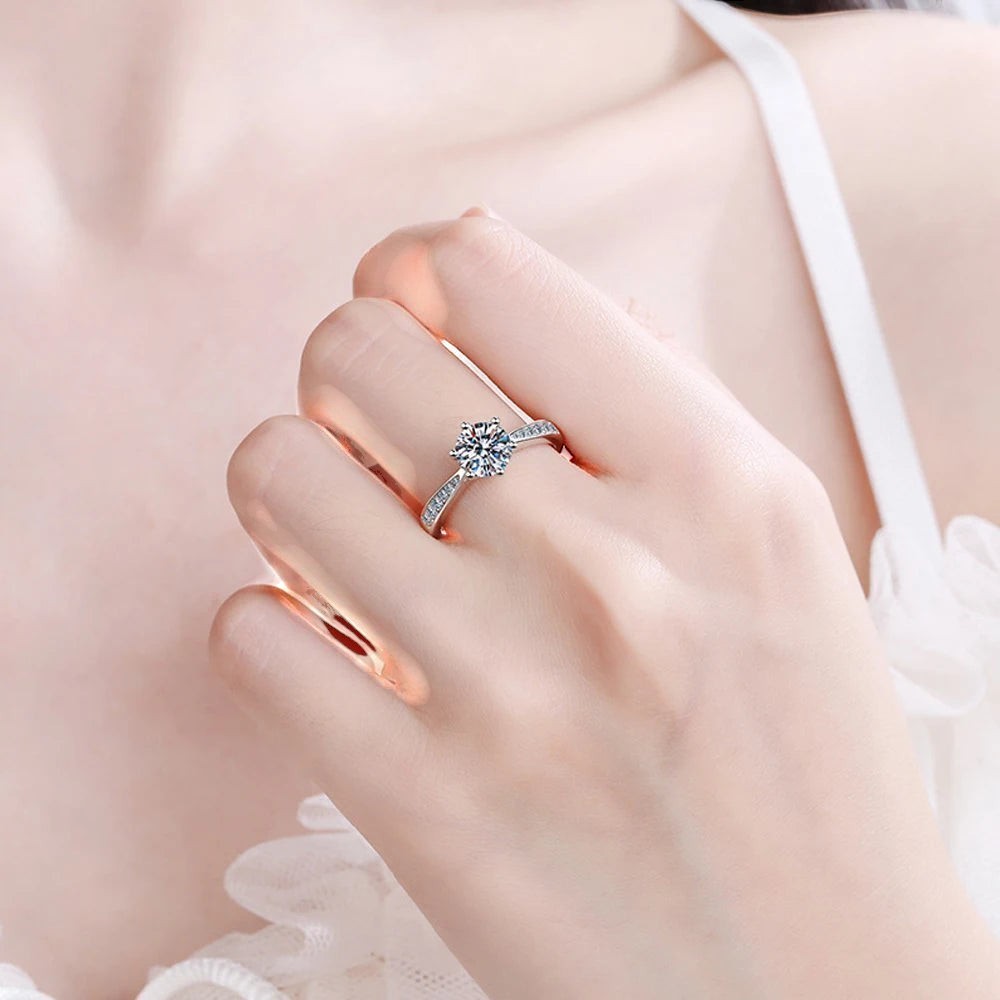 Bee-Bee's sterling silver solitaire engagement ring with round D VVS1 moissanite and small accent stones on band.