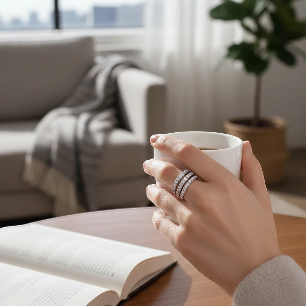 Bee-Bee's Sterling silver spiral eternity band with D VVS1 moissanite stones, worn on a hand holding a mug.