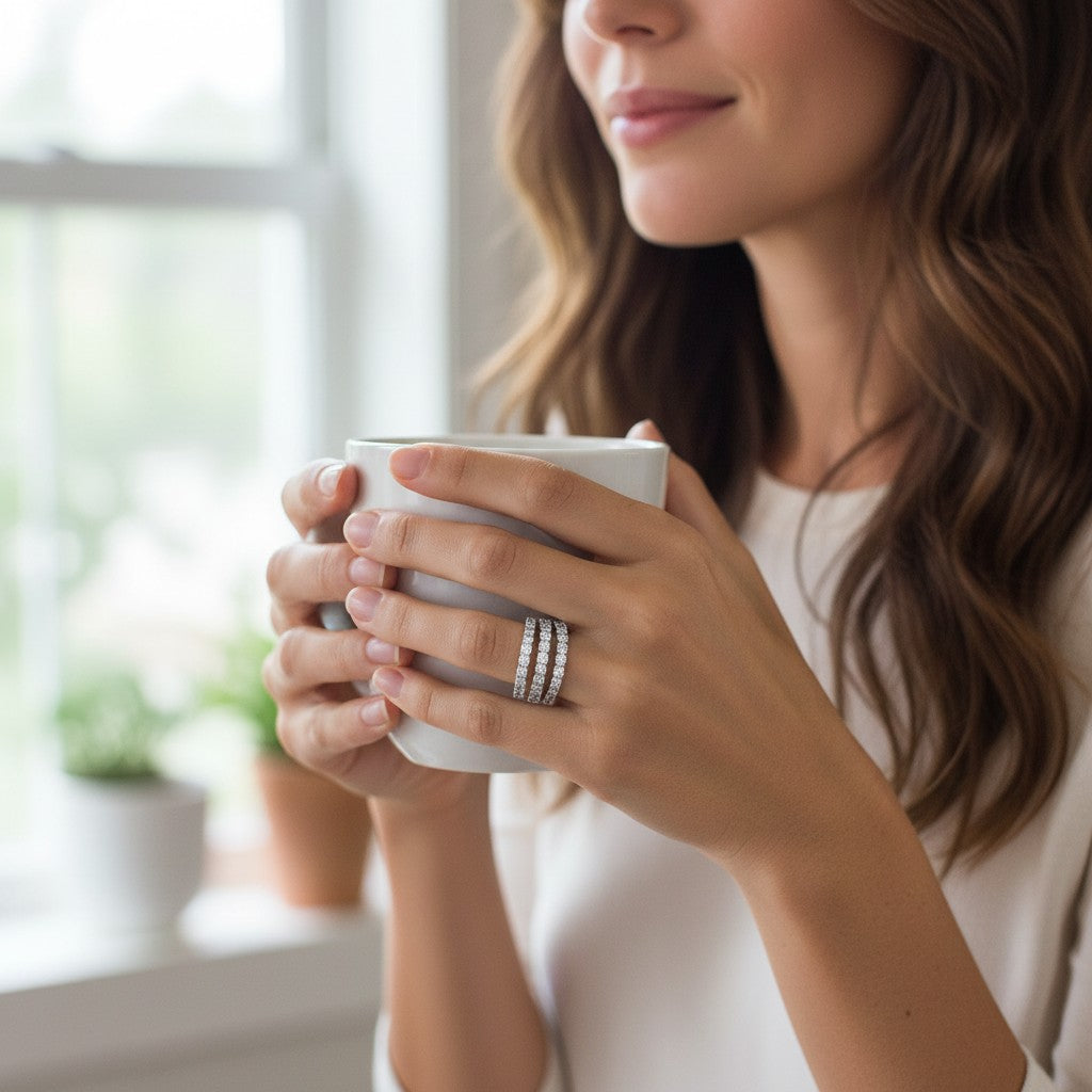 Bee-Bees spiral moissanite eternity band in sterling silver worn by a woman holding a white coffee mug