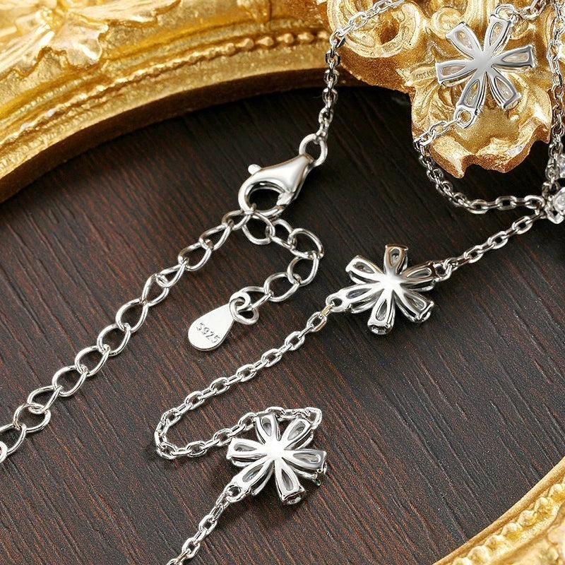 Bee-Bee's sterling silver necklace with flower charms and pear cut moissanite. Features adjustable clasp and S925 stamp.