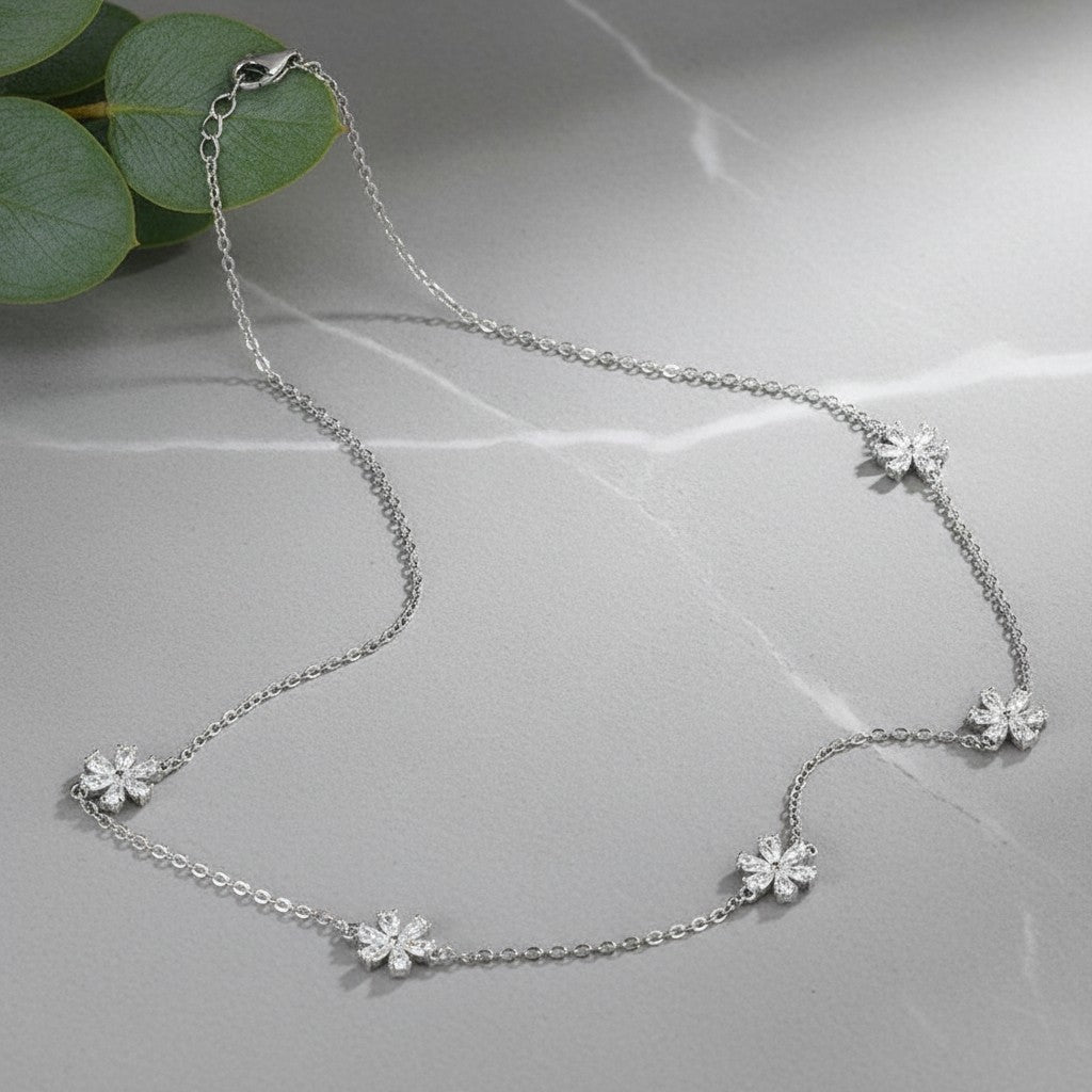 Bee-Bee's Sterling silver necklace with small flower charms, featuring clear cubic zirconia stones. Delicate and elegant.