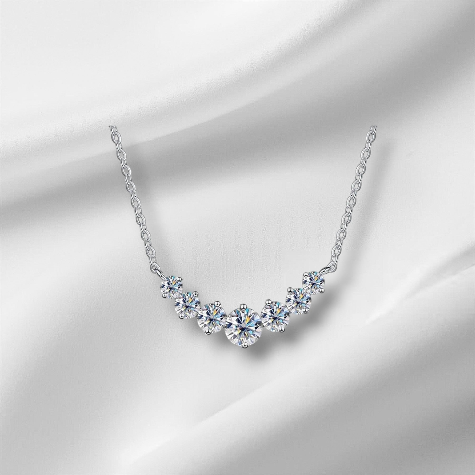 Bee-Bee's sterling silver necklace with a curved row of seven round-cut moissanite stones, 18K white gold plated.