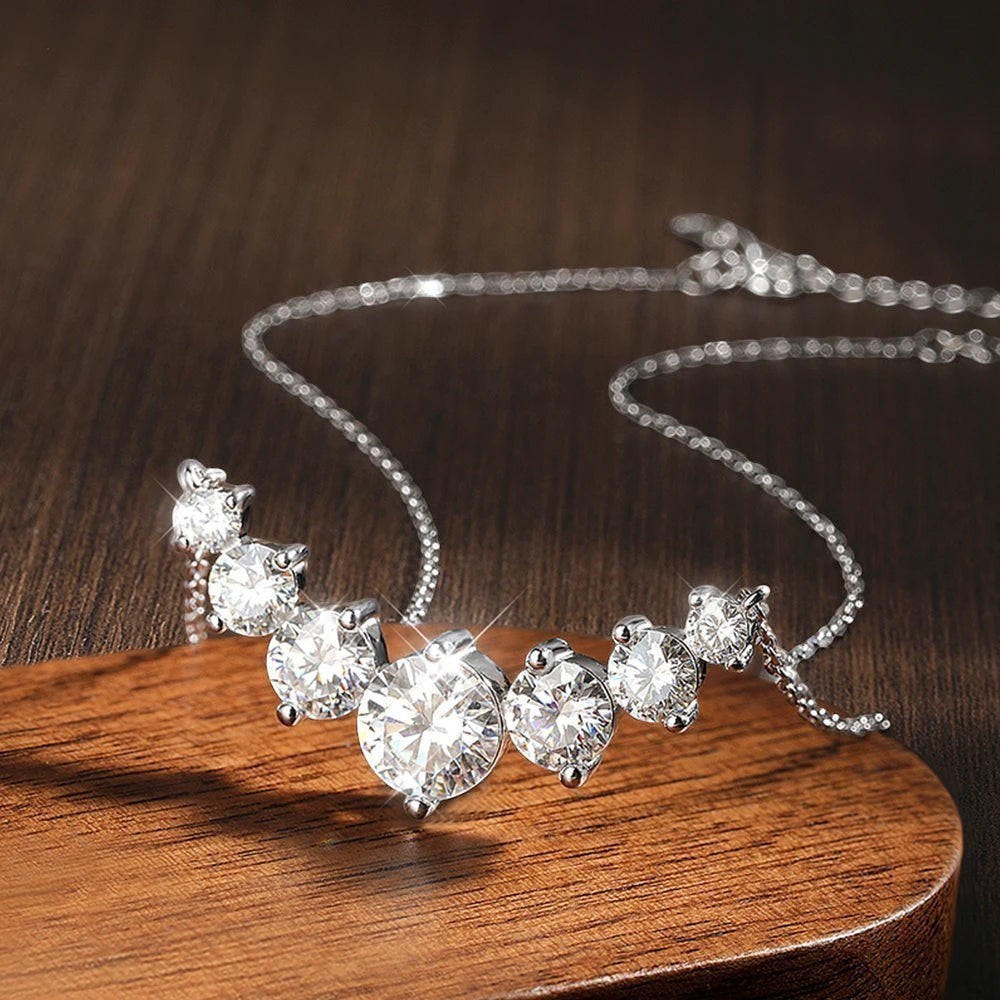 Bee-Bee's sterling silver necklace with five round-cut moissanite stones in graduating sizes, set on a delicate chain.