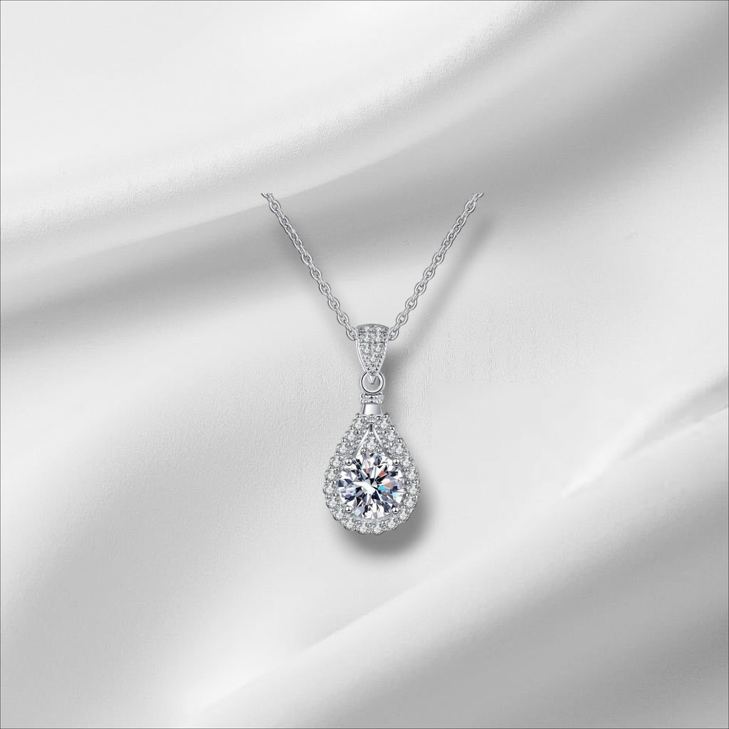 Bee-Bees teardrop pendant necklace with a D Color VVS1 moissanite surrounded by small stones, set in 925 sterling silver with a white gold finish.