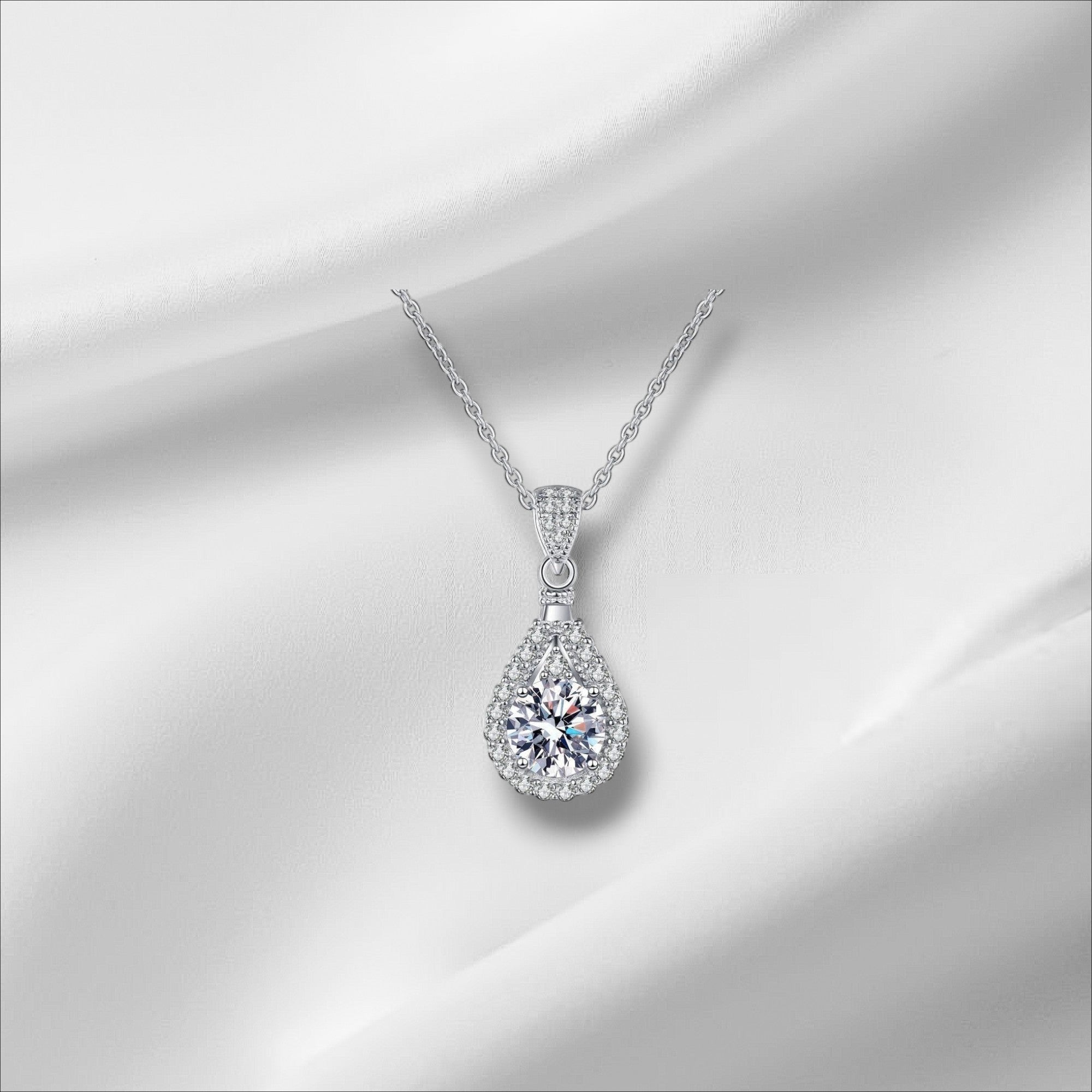Bee-Bees teardrop pendant necklace with a D Color VVS1 moissanite surrounded by small stones, set in 925 sterling silver with a white gold finish.
